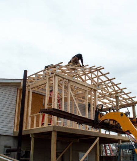 Unidentified carpenters work on the new roof, aided by some heavy equipment. Construction work is progressing nicely